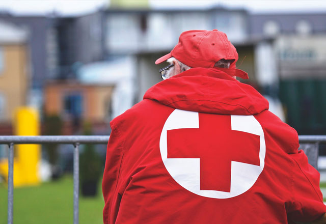 Man in a red cross coat - senior volunteer opportunities