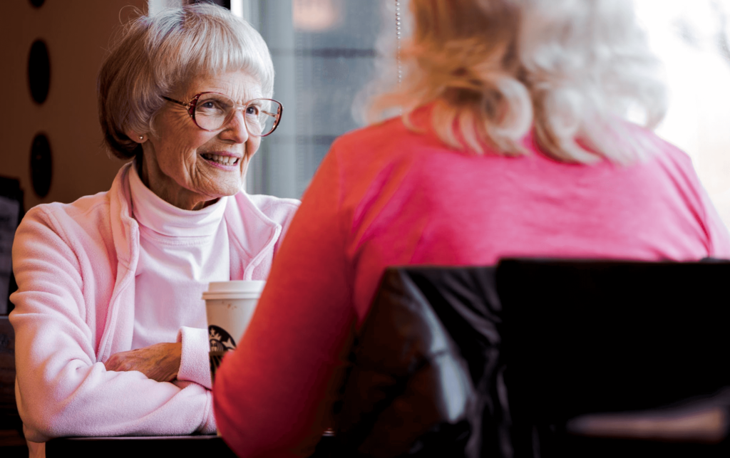 Woman at coffee with a senior loved one - covid vaccine and elder care