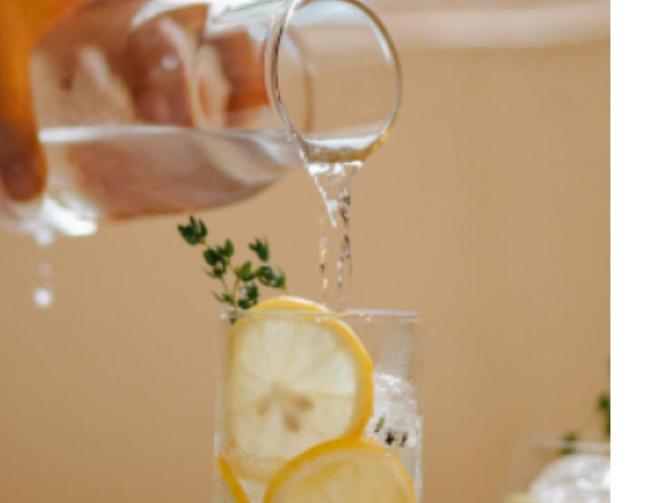 7 Tips to Stay Hydrated and Healthy When the Weather Turns Hot water pouring into a glass with a lemon slices