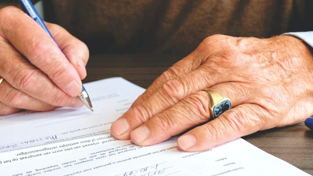 Hands showing signing a POA Sign-Power-of-Attorney-Place-for-Mom